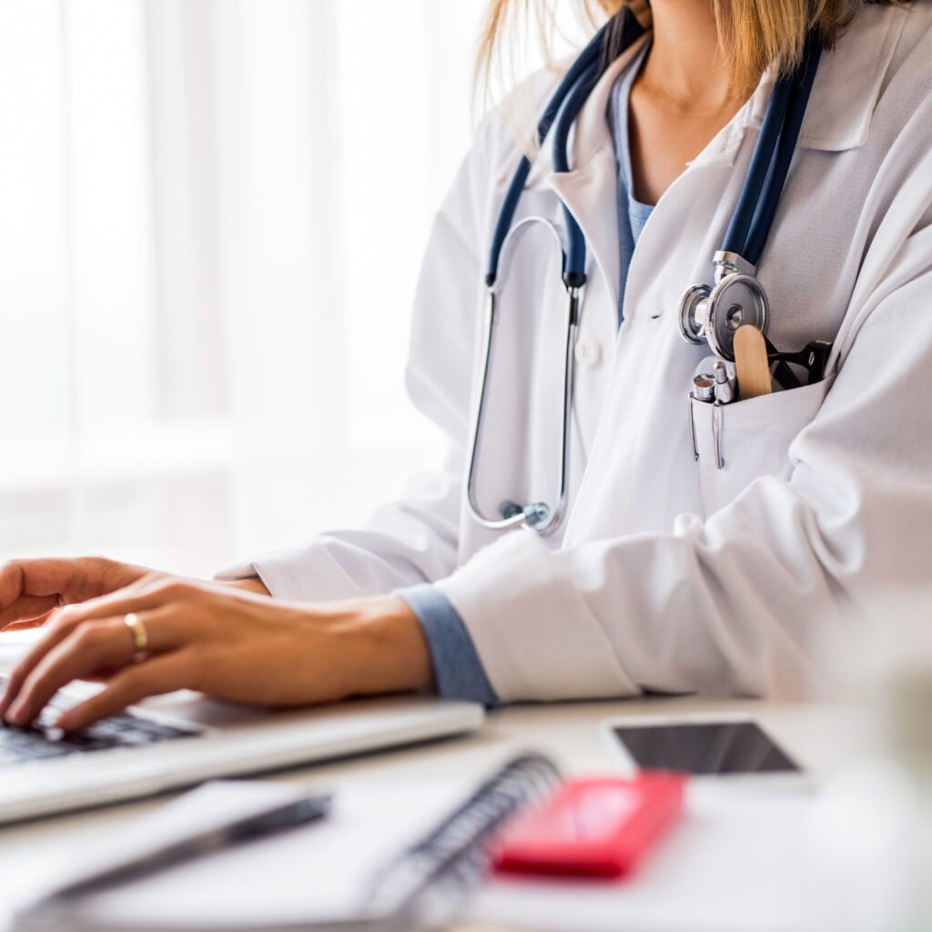 Female doctor with laptop working at the office desk.